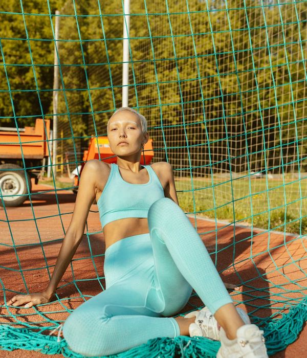 Woman performing a serene yoga pose in a sunlit park.